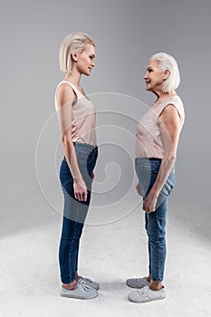 Tall appealing young woman pleasantly looking on her mother photo