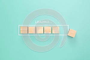 Showing loading bar with wood cube on pastel background. Progress bar made from wooden cubes. Loading. Top view