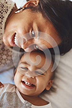 Showing off all his teeth. a mother and her adorable son lying together.