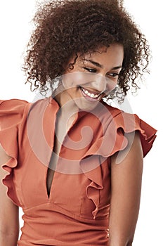 Showing off a demure style. Cute young african american woman looking away shyly and smiling.