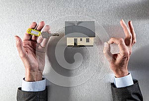 Symbol of zen home ownership with house key in hands