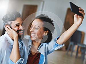 Showing the world how much I adore you. a happy couple posing for a selfie together at home.