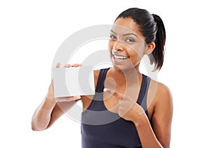 Showing you the way - Copyspace. A pretty young woman pointing at a blank card while isolated on a white background.