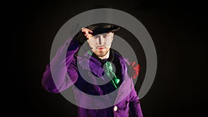 Showman touches the hat. Young male entertainer, presenter or actor on stage.
