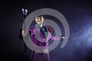 Showman. Young male entertainer, presenter or actor on stage. The guy in the purple camisole and the cylinder.