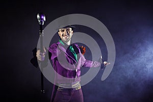 Showman. Young male entertainer, presenter or actor on stage. The guy in the purple camisole and the cylinder. photo