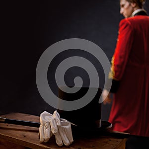 Showman. Young male entertainer, presenter or actor on stage. The guy in the red camisole and the cylinder.