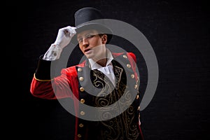 Showman. Young male entertainer, presenter or actor on stage. The guy in the red camisole and the cylinder.