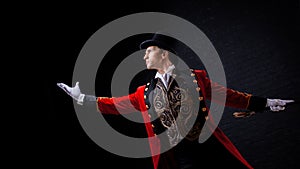 Showman. Young male entertainer, presenter or actor on stage. The guy in the red camisole and the cylinder.