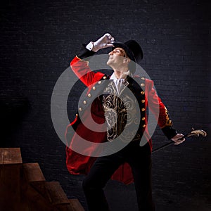 Showman. Young male entertainer, presenter or actor on stage. The guy in the red camisole and the cylinder. photo