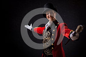 Showman. Young male entertainer, presenter or actor on stage. The guy in the red camisole and the cylinder. photo