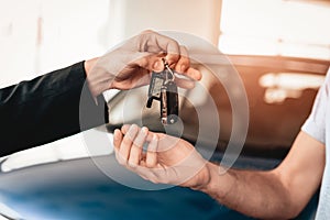 Showroom Dealer The Gives Car Keys To The Buyer.