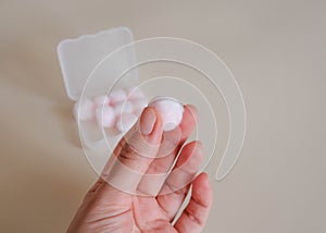 Shows a soft cotton ball in which a wax earplug is wrapped.