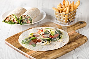Shredded barbecued chicken wraps with carrot, cheese, avocado an