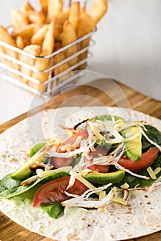 Shredded barbecued chicken wraps with carrot, cheese, avocado an