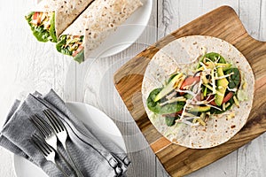 Shredded barbecued chicken wraps with carrot, cheese, avocado an