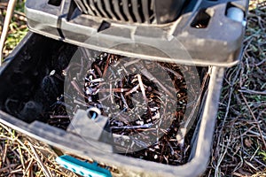 shredded branches and vines in a container electric garden grinder to shred, a tool for cutting wood waste and pruning