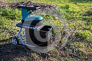 shredded branches and vines in a container electric garden grinder to shred, a tool for cutting wood waste and pruning