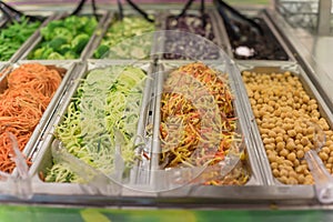 Shredded carrot, cucumber, tofu and bean at salad bar in high-end grocery store in USA