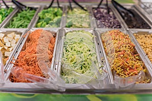 Shredded carrot, cucumber, tofu and bean at salad bar in high-end grocery store in USA