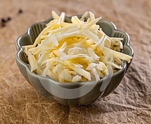 Shredded cheese filling a bowl