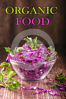 Shredded red cabbage with parsley in a transparent bowl on a dark wooden background, Vegetarian healthy food, organic food