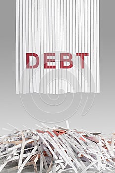 Shredded red DEBT letters above Cut up credit cards on Shredded Bills and Bank Statements