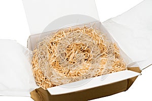 Shredded white paper cushioning in cardboard box