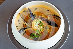 Shrimp Bisque with Seafood. King prawn, blue mussels, cod, whipped cream. Delicious traditional food closeup served for