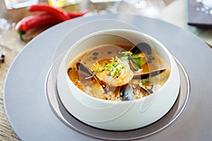 Shrimp Bisque with Seafood. King prawn, blue mussels, cod, whipped cream. Delicious traditional food closeup served for