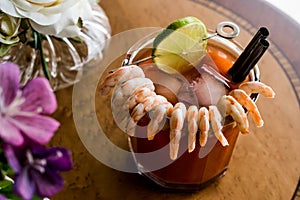 Shrimp Cocktail with red sauce, lime and ice.