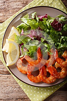 Shrimp fried in soy sauce and fresh salad close-up. Vertical top