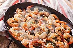 Shrimp in garlic sauce with parmesan cheese and herbs in a pan c