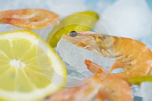 Shrimp and lemon wedges lie on ice