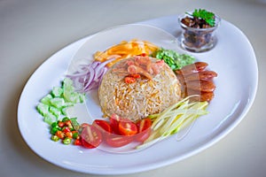 Shrimp paste fried rice is served with sweet pork, sliced fried egg, fried dry shrimp and Thai sausage, chopped red onion, chili