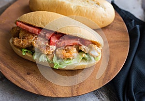 Shrimp po boy sandwich with tomato and lettuce.