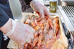 Shrimp raw in marinade with garlic and sauce on skewers. Ingredient for cooking. Dietary or vegetarian dish.