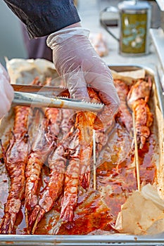 Shrimp raw in marinade with garlic and sauce on skewers. Ingredient for cooking. Dietary or vegetarian dish.