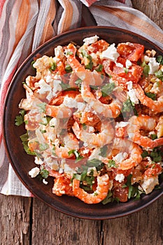 Shrimp saganaki with tomato and feta cheese close-up. vertical t