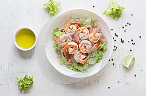 Healthy food shrimp salad lettuce carrot tomato in bowl on wood background