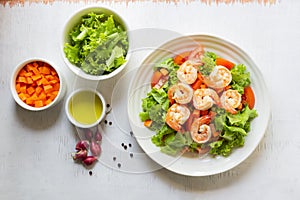 Healthy food shrimp salad lettuce carrot tomato in bowl on wood background