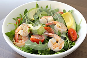 Shrimp Scampi Salad with Arugula, Cherry Tomatoes, and Avocado Slices in a White Bowl