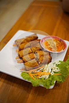 Shrimp spring rolls with pickled vegetables and fresh vegetables on a white plate photo