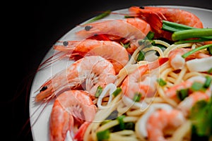 Shrimp and squid with pasta on a white plate. restaurant.