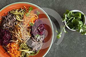 Shrimp vegetable salad in batter on a dark wooden table, oriental and asian cuisines, gourmet asian salad in a square dish, orient