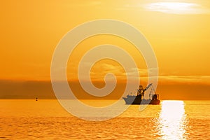 Shrimping boat at sunset on ocean