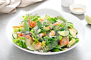 Shrimps salad with green lettuce, cucumbers and avocado, dressed with lime juice, healthy and tasty food