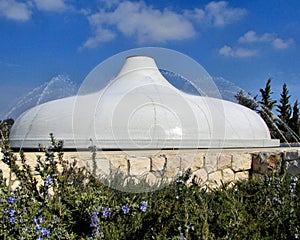 Shrine of the Book in Jerusalem white tiled roof with water sprinklers and blue sky