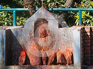 Shrine covered in vermillion to worship Goddess Kali. Red pigment powder on stone, Kali Shrine in Dhulikhel, Nepal