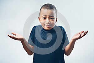 Shrugging, doubt and portrait of a child with a decision isolated on a white background in a studio. Confused, young and